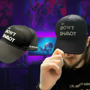 Černá kšiltovka ARC Raiders Don't Shoot – samotná kšiltovka z boku a muž, který si ji nasazuje, vpředu bílý nápis DON'T SHOOT