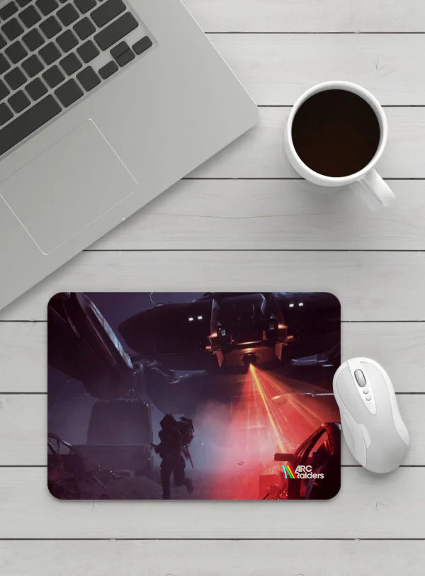 Podložka pod myš ARC Raiders na bílém stole vedle notebooku, myši a šálku kávy