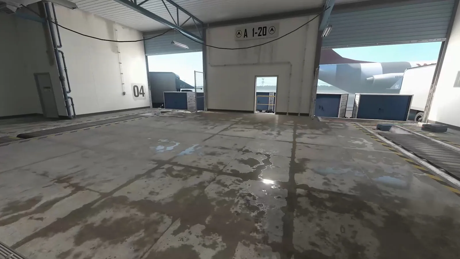 Hala v CS2 s mokrou betonovou podlahou, ve které se odráží světlo z otevřených vrat