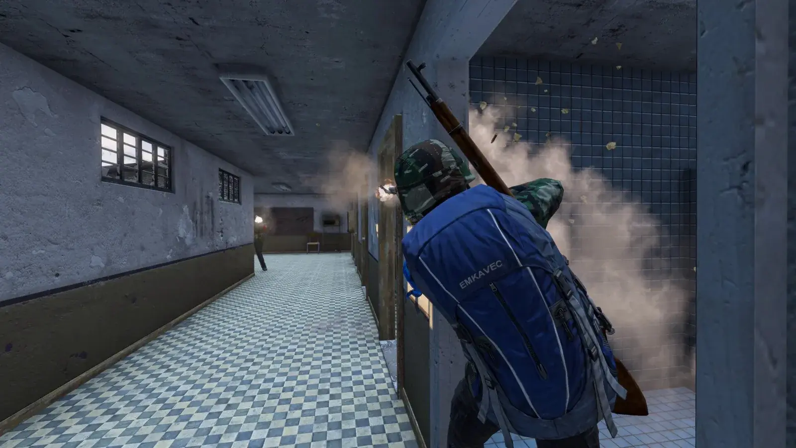 Hráč s batohem a puškou se kryje u dveří v zakouřené chodbě