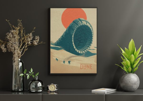 Plakát Dune Shai-Hulud v černém rámu na tmavé stěně – tyrkysový píseční červ před oranžovým sluncem