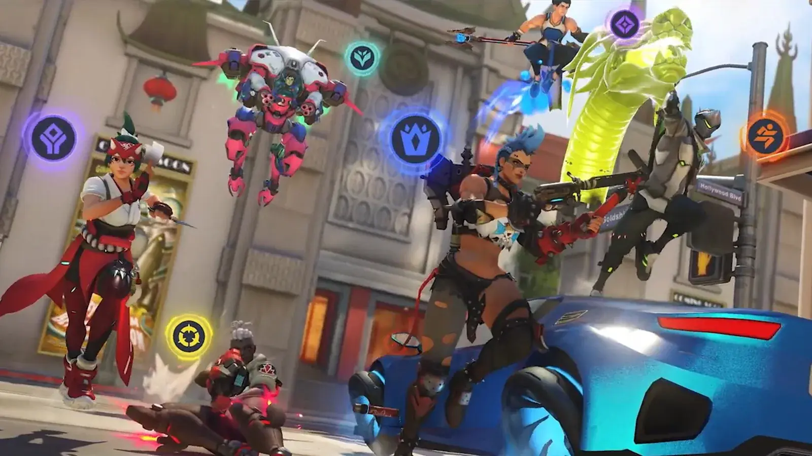 Skupina hrdinů Overwatch v útoku na ulici, nad nimi kulaté ikony