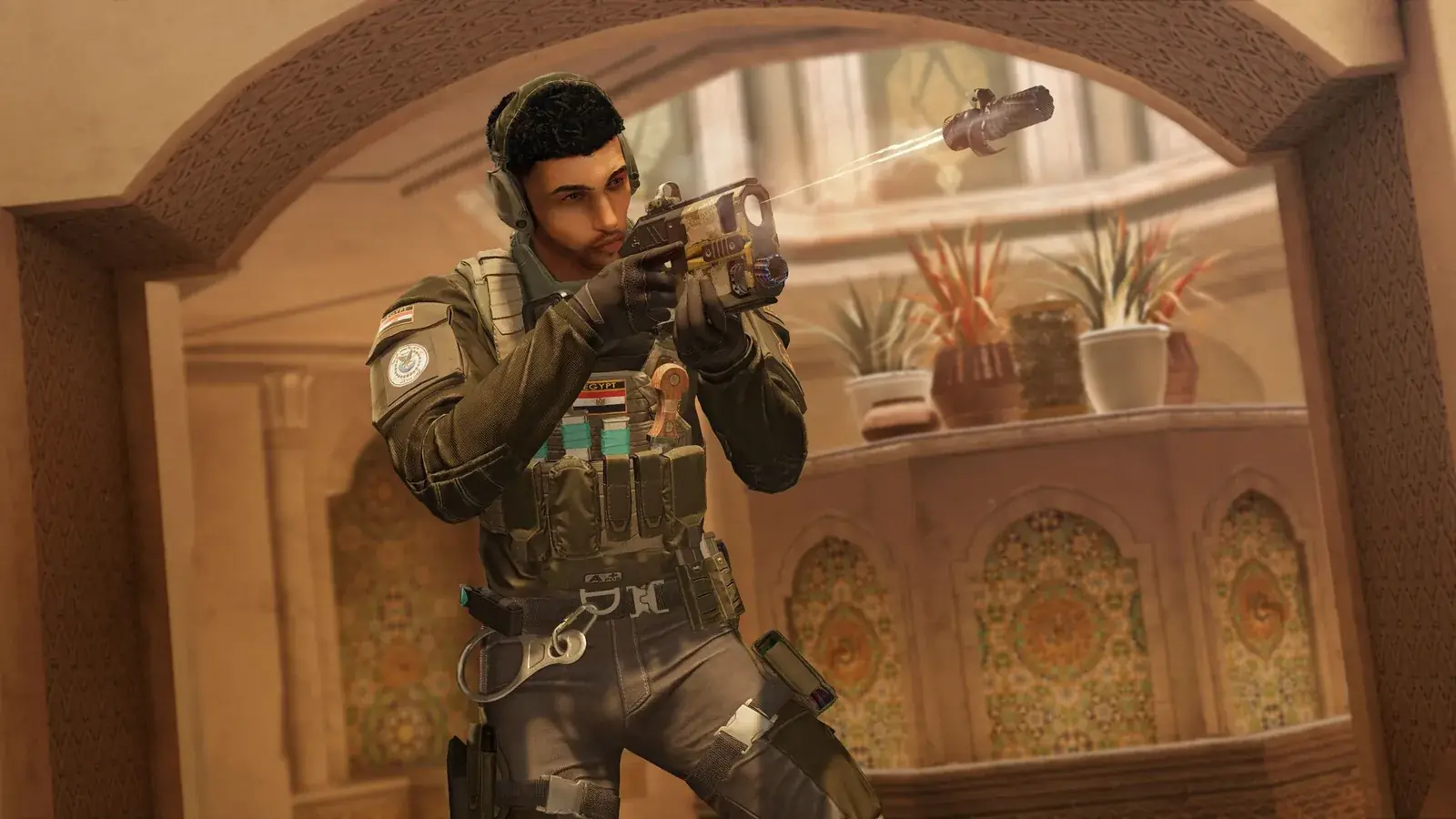 Operátor v helmě míří pistolí pod orientálním obloukem, Rainbow Six Siege