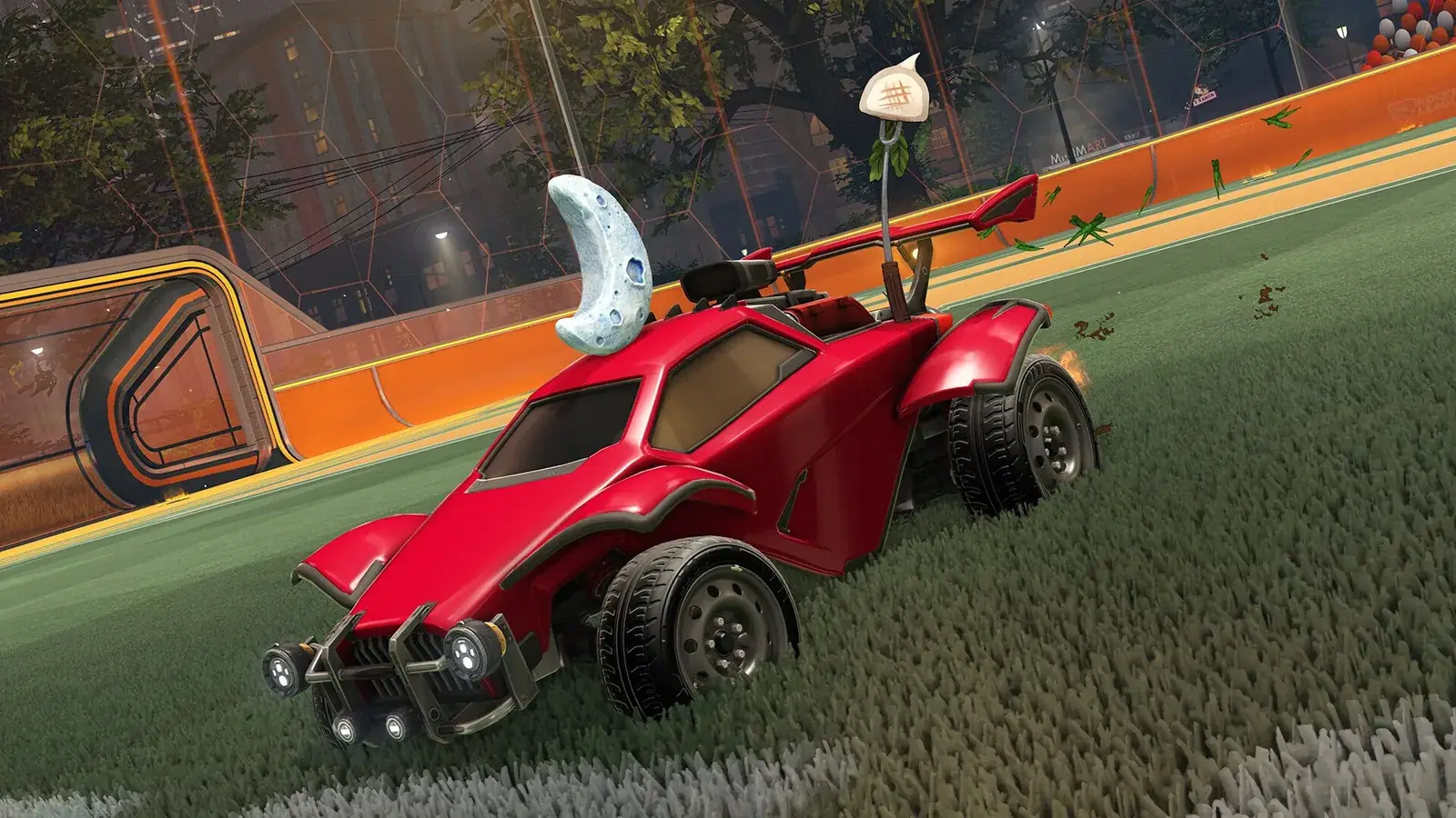 Červené auto Rocket League na trávníku hřiště v noci