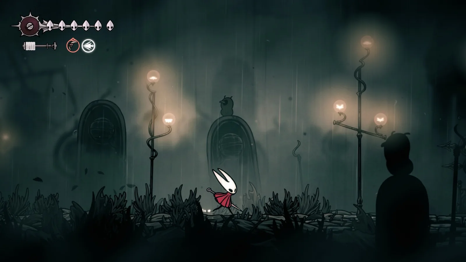 Hornet kráčí tmavým mlžným městem v dešti s lucernami